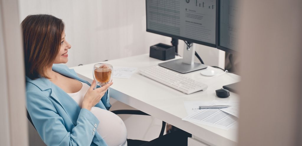 امرأة حامل تحتسي القهوة في العمل