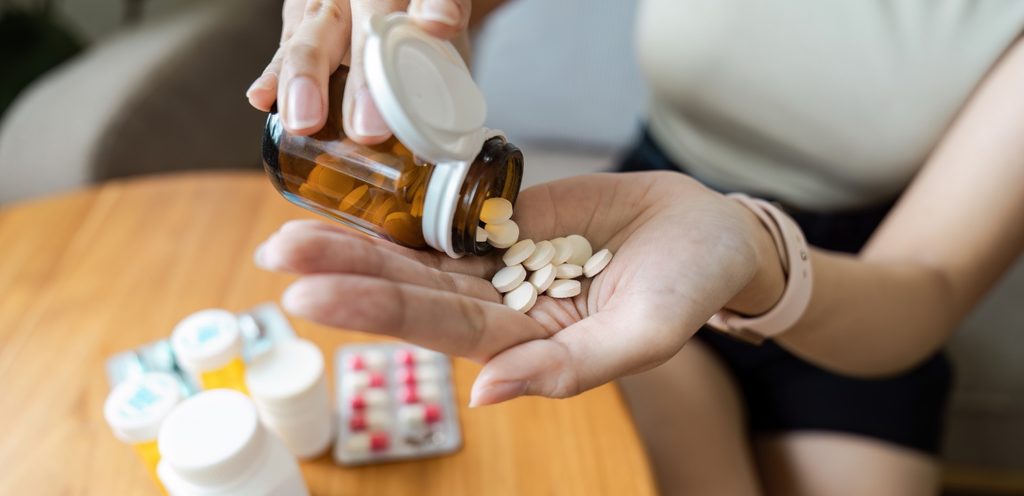 امرأة تمسك حبوب دواء