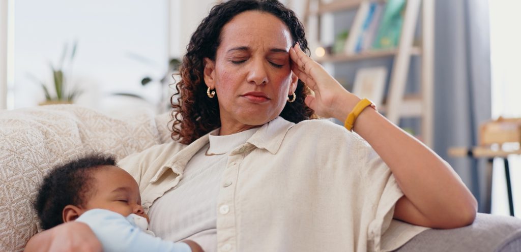 أم متعبة تحمل طفلها