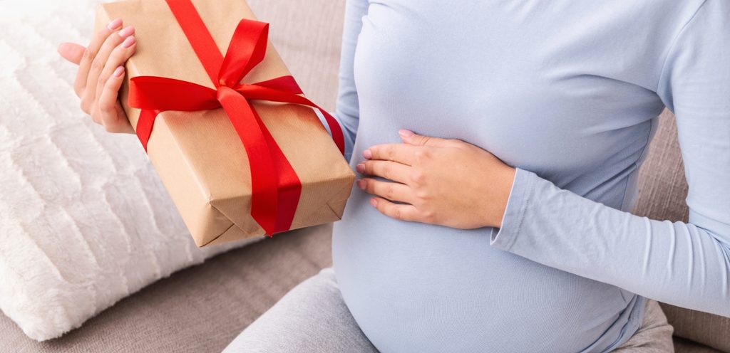 امرأة حامل تمسك هدية