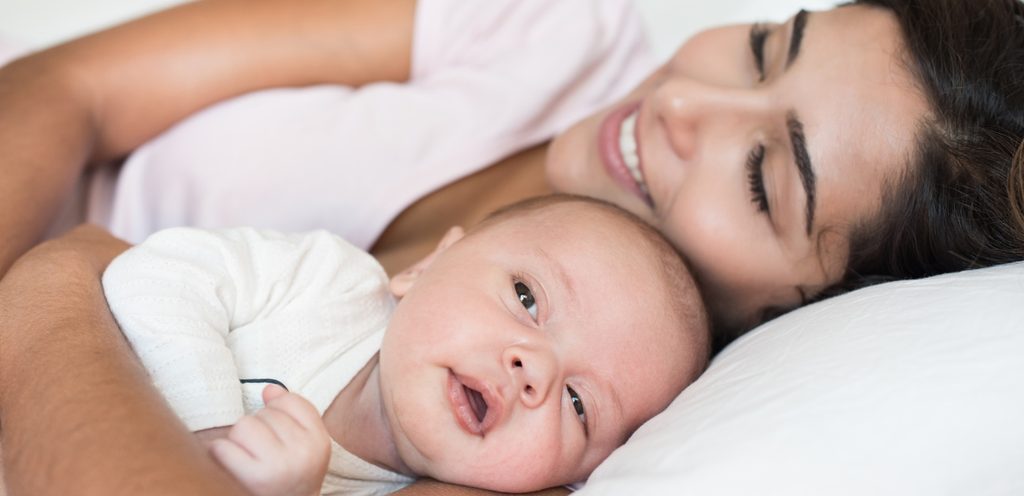 امرأة مستلقية بجانب رضيعها
