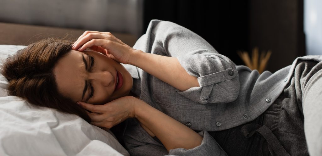 امرأة تعاني من مشاكل في النوم مستلقية على السرير