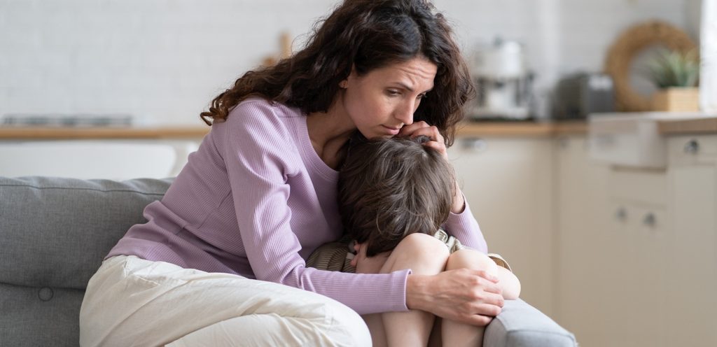 امرأة تعانق طفلها الحزين