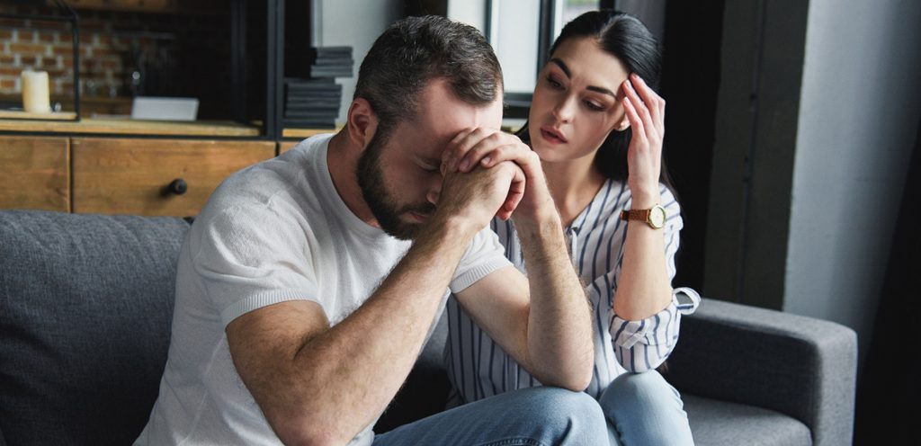 رجل حزين وزوجته بجانبه