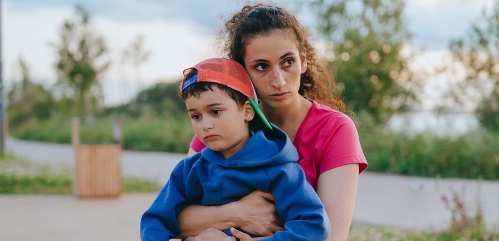 امرأة حزينة تعانق طفلها الحزين