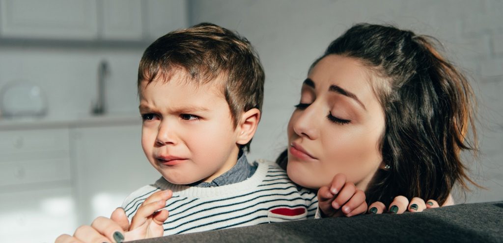 امرأة تعانق طفلها الذي يبكي