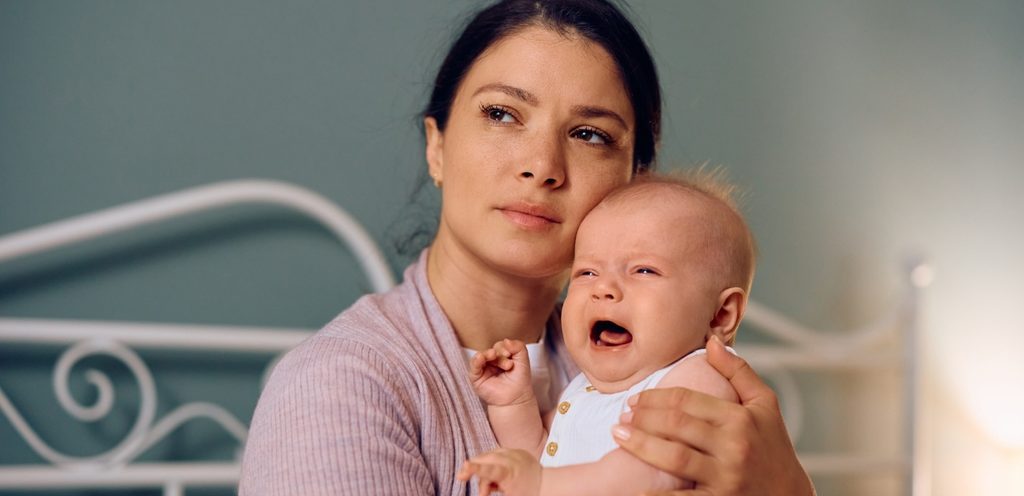 أم قلقة تحمل طفلها