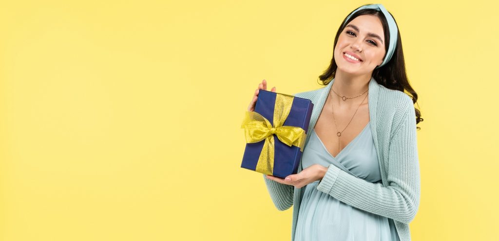 امرأة حامل تمسك هدية