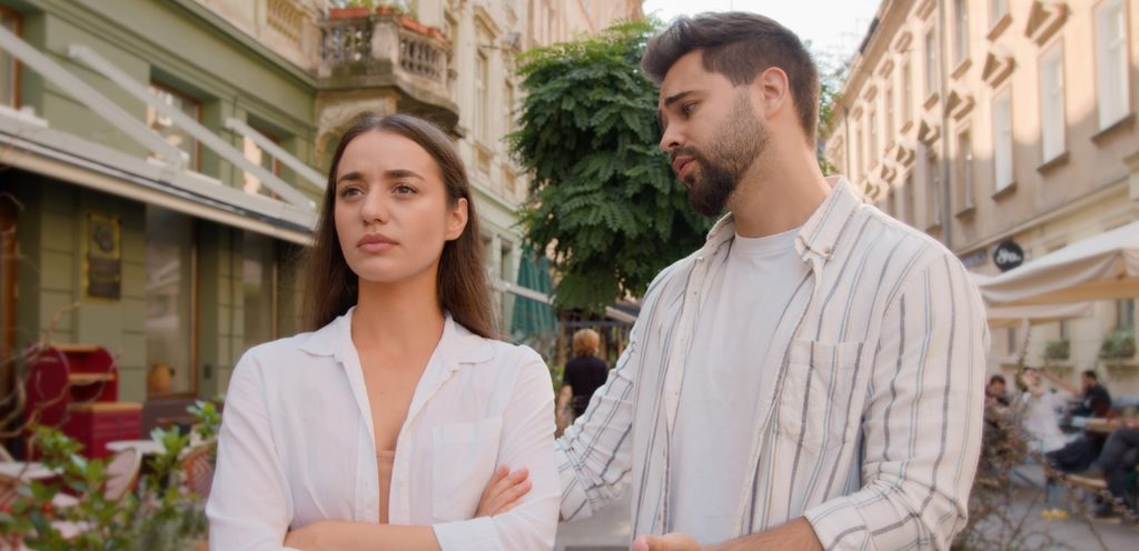 امرأة حزينة ورجل يحاول إرضاءها