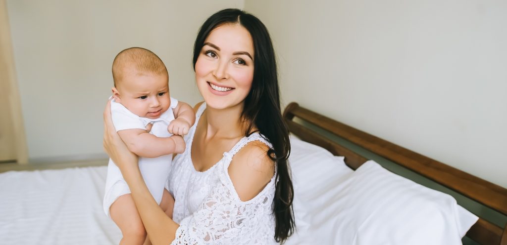 أمّ سعيدة تحمل رضيعها