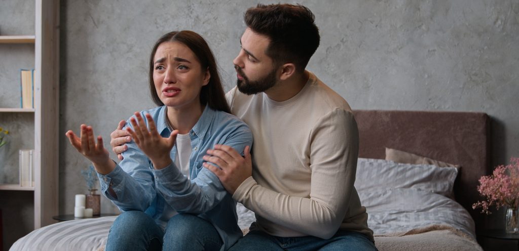 امراة تبكي وزوجها يحاول مواساتها