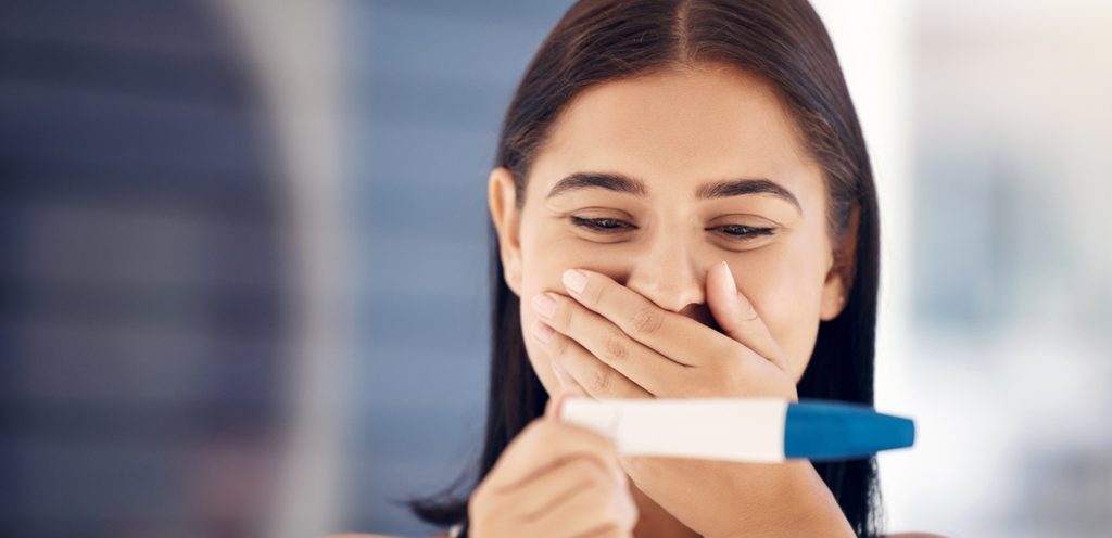 امرأة سعيدة تمسك اختبار حمل