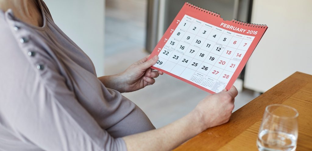 امرأة تمسك ورقة تواريخ