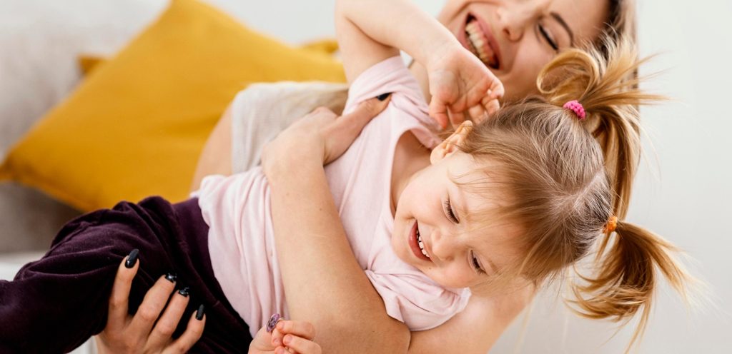 أم تداعب طفلتها بسعادة