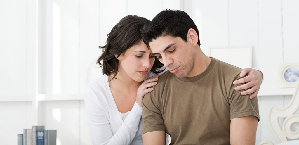 رجل حزين وامرأة تحاول التقرّب منه