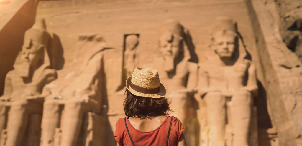 امرأة تقف أمام آثار مصرية