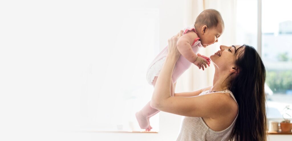 أم تحمل رضيعها بسعادة