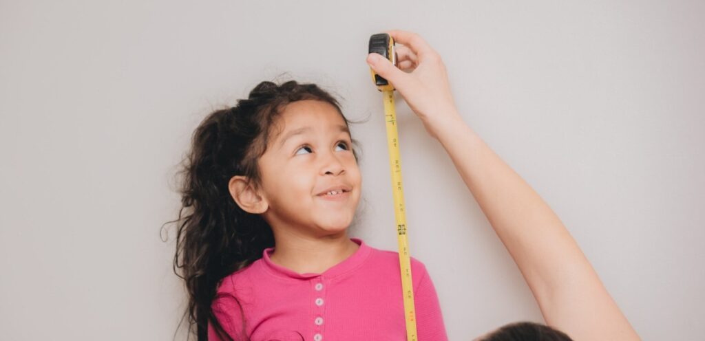 طفلة تقيس طولها
