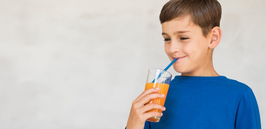 طفل سعيد يشرب العصير
