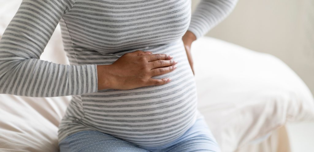 امرأة حامل تضع يدها على بطنها