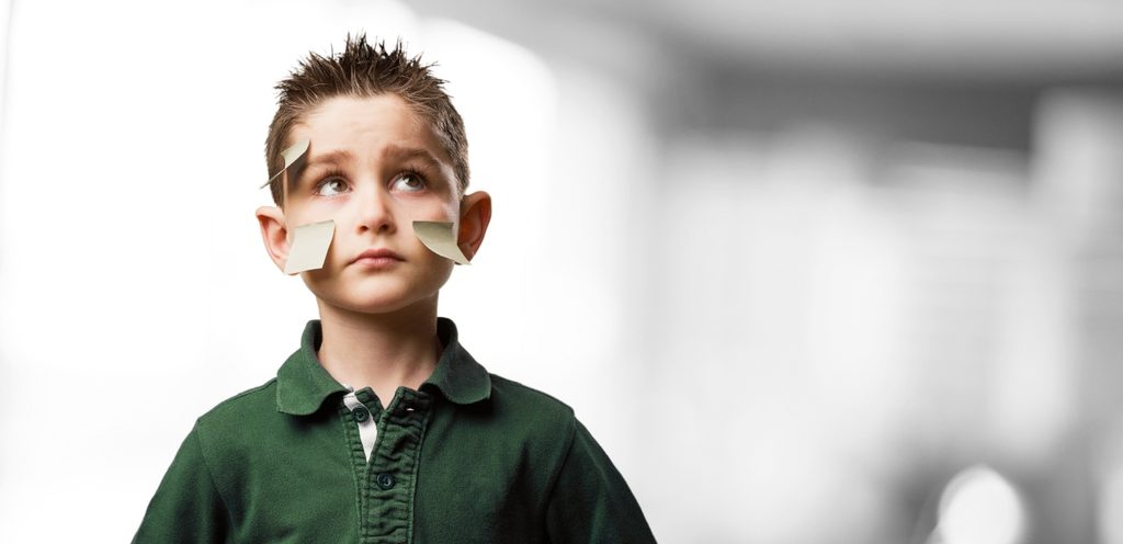 طفل حزين على وجهه أوراق