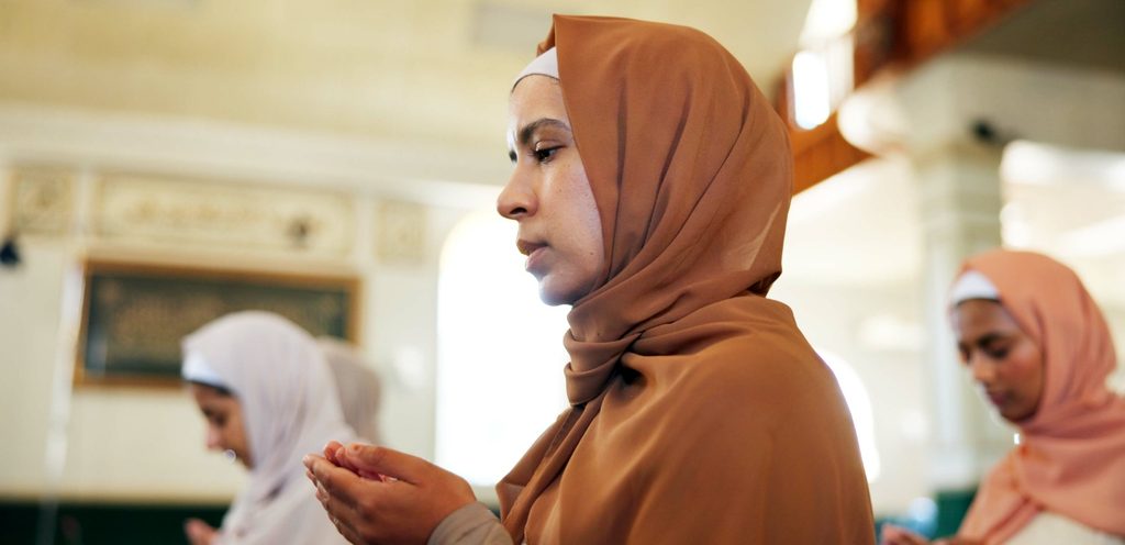 امرأة ترفع يديها للدعاء