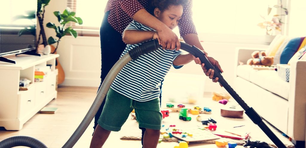 امرأة تعلّم طفلها كيفيّة تنظيف الأرض