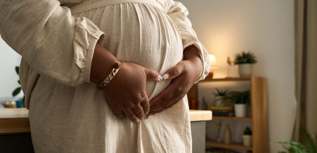 امرأة حامل تضع يديها على بطنها