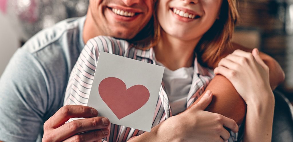 زوجان سعيدان يمسكان قلبًا