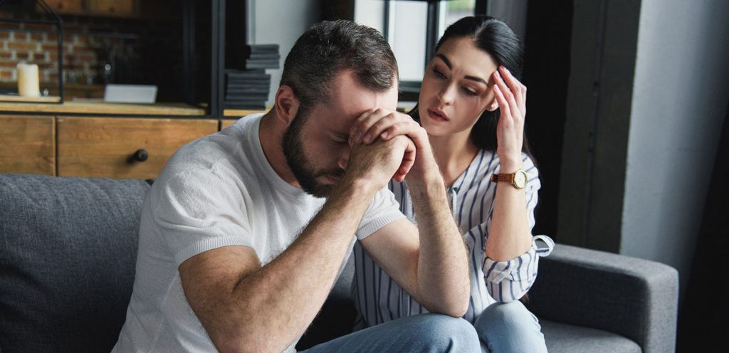 رجل حزين وزوجته تحاول مواساته