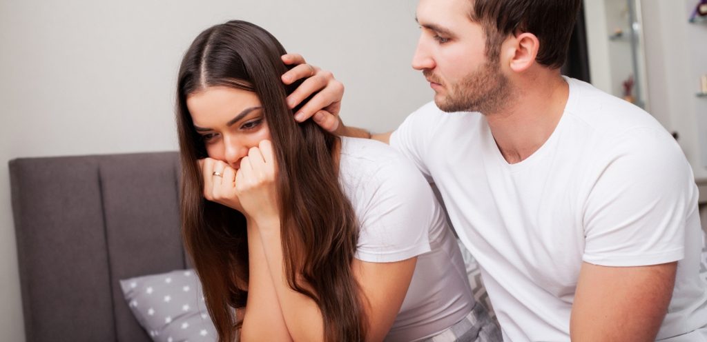 امرأة حزينة و زوجها يحاول مواساتها