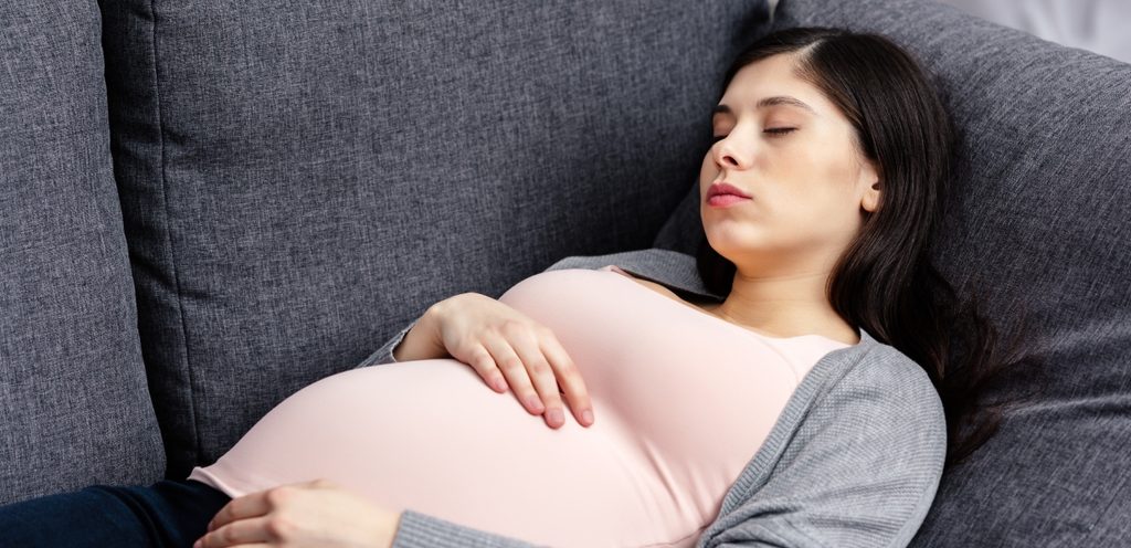 امرأة حامل نائمة على ظهرها