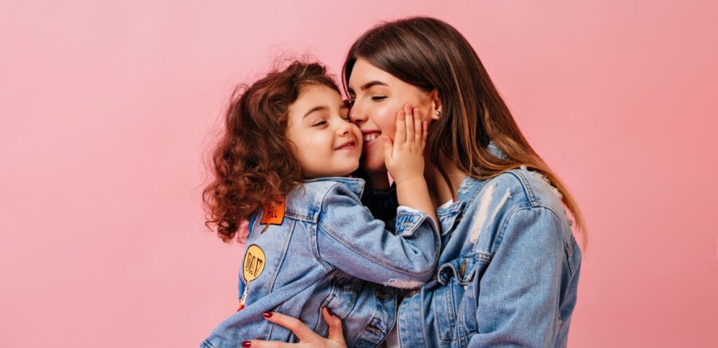 امرأة تقبّل طفلتها