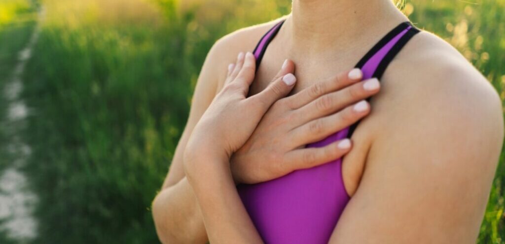 امرأة تضع يديها على ثديها