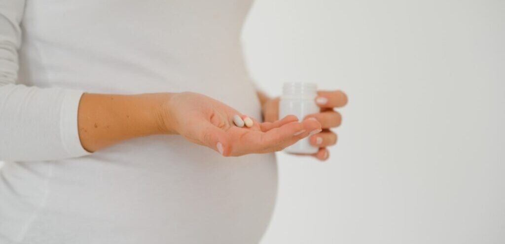 امرأة حامل تمسك حبوب من الدواء