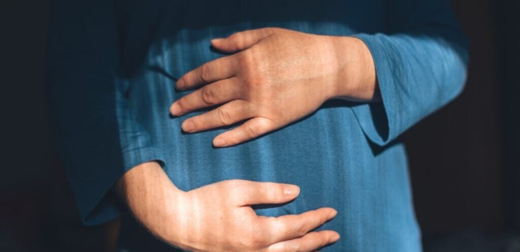 امرأة حامل تضع يديها على بطنها