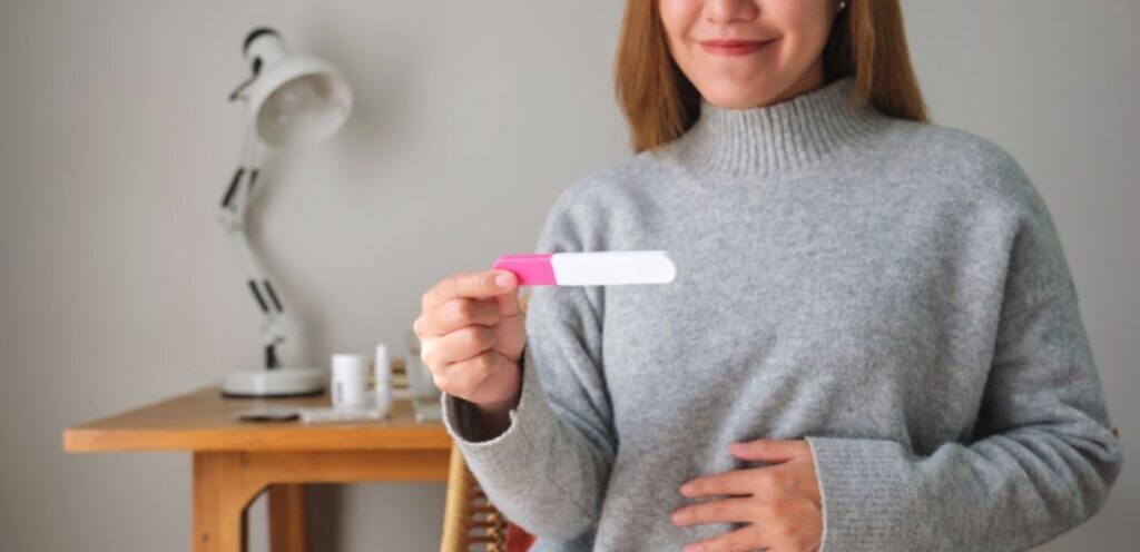 امرأة تمسك اختبار حمل