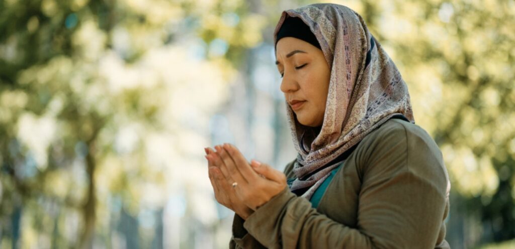 امرأة ترفع يديها للدعاء