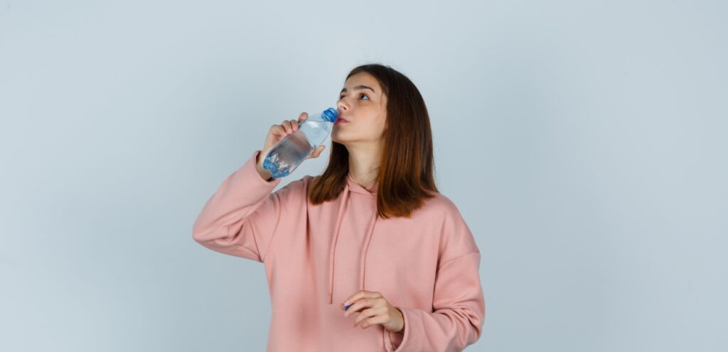 امرأة تشرب مياه من عبوة بلاستيكيّة