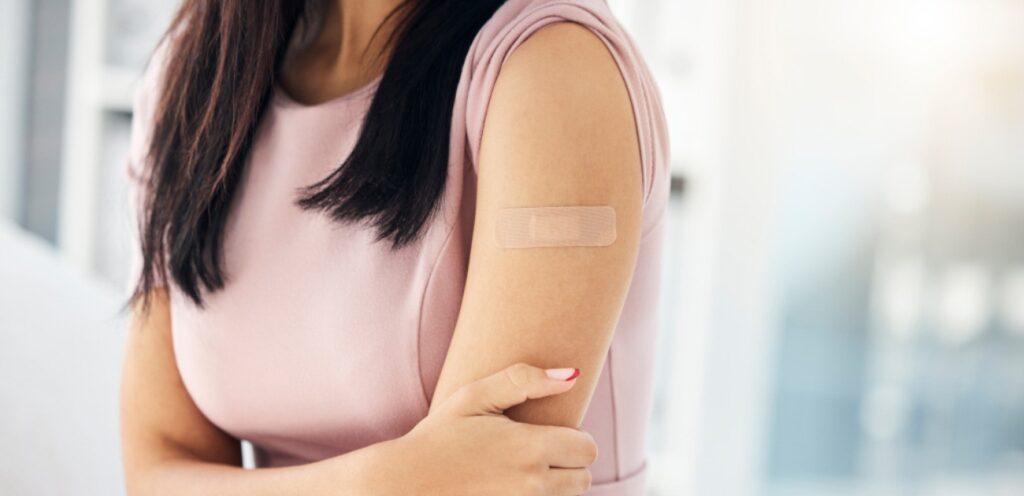 امرأة تضع لصقة على ذراعها