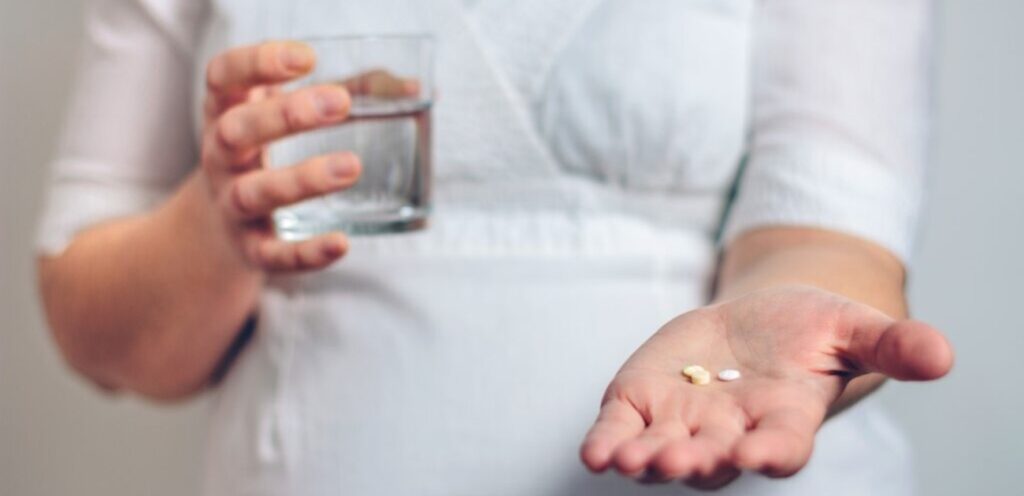 امرأة حامل تمسك حبوب من الدواء