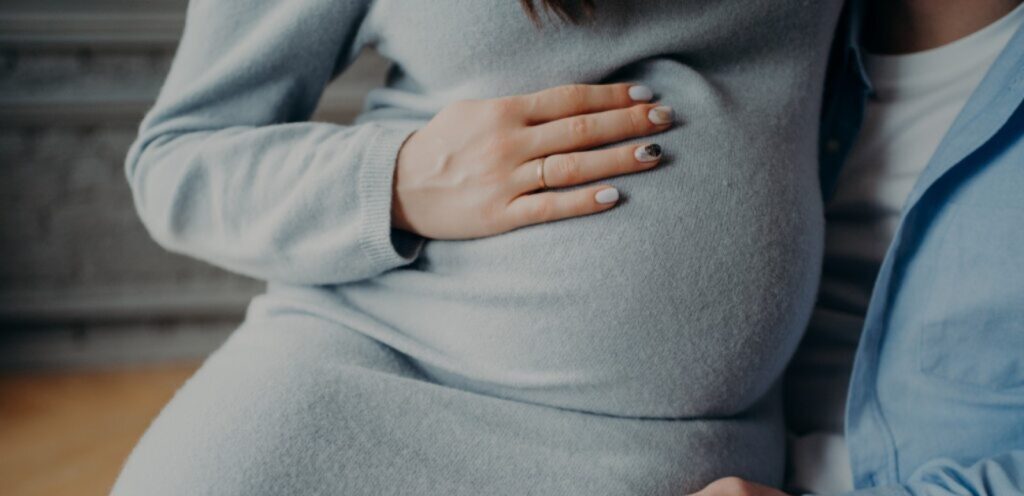 امرأة حامل تضع يديها على بطنها