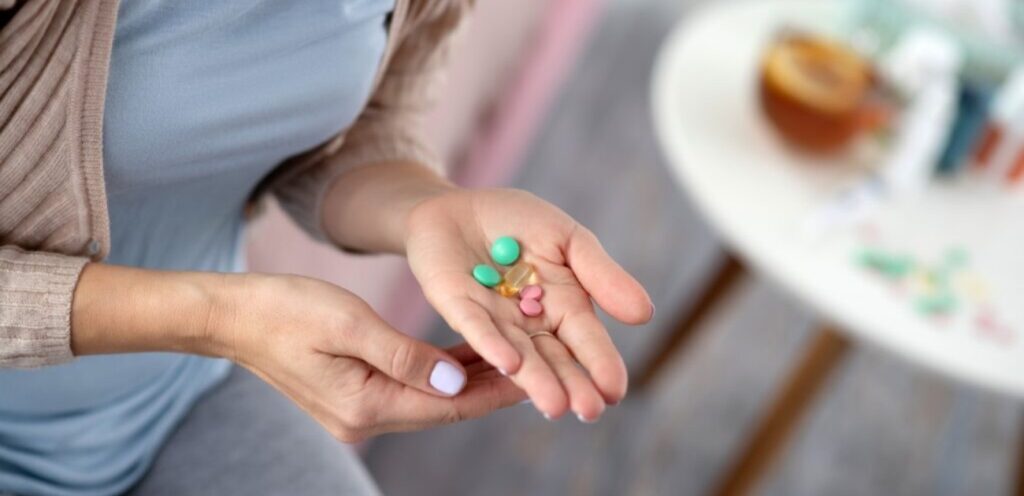 امرأة تمسك حبوب دواء