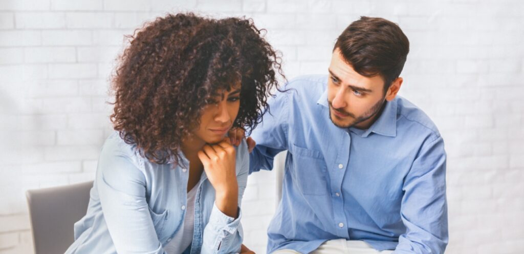 امرأة حزينة وزوجها يواسيها