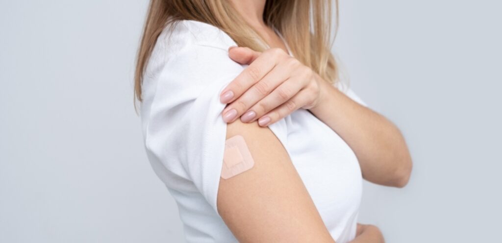 امرأة تضع لصقة على ذراعها