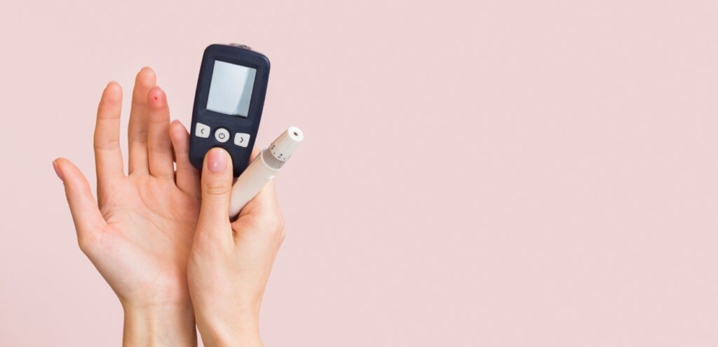 امرأة تمسك آلة قياس معدّل السكر في الدم