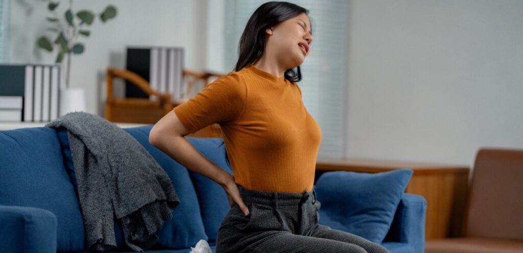 امرأة تعاني من آلام في الظهر