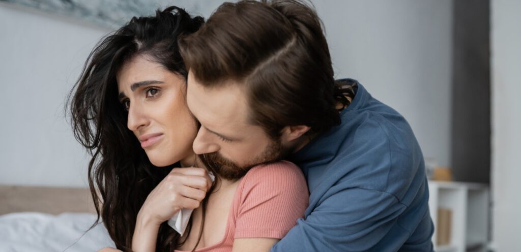 امرأة حزينة وزوجها يواسيها