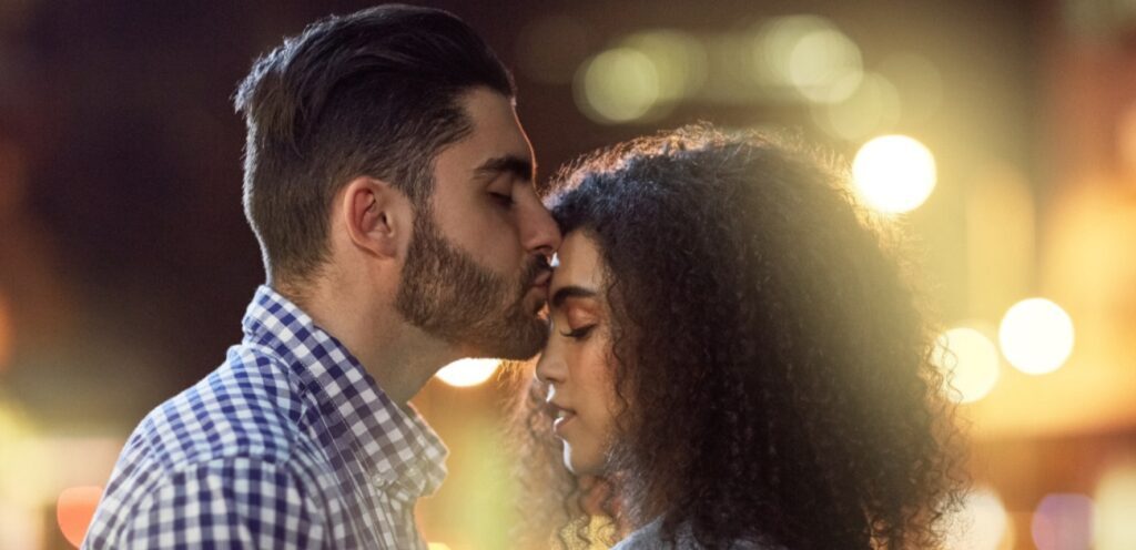 رجل يقبّل شريكته في رأسها