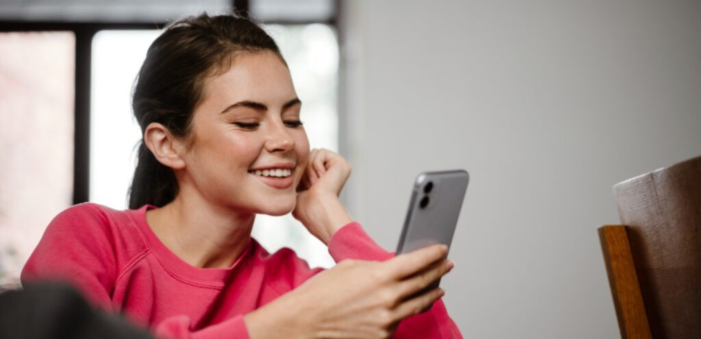 امرأة سعيدة تمسك جوّالها